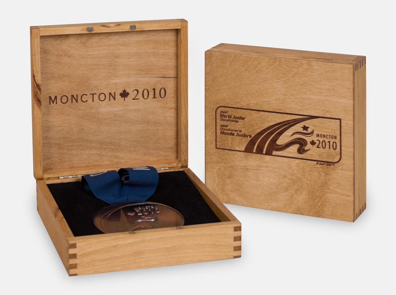 Hinged wooden medal display box with a foam insert and ribbon cutout.